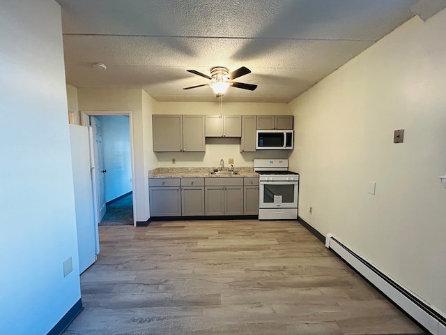 kitchen featuring white appliances, light hardwood / wood-style floors, a baseboard radiator, and ceiling fan