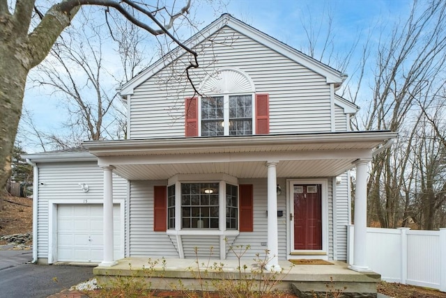 traditional-style house with driveway, a porch, an attached garage, and fence