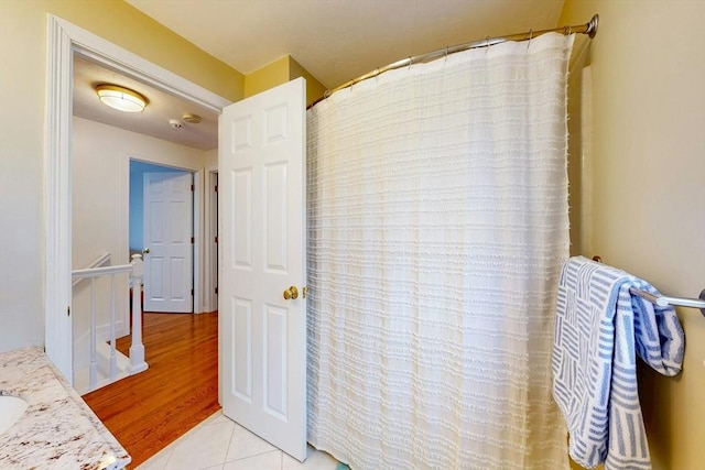 full bath with a shower with shower curtain, tile patterned flooring, and vanity