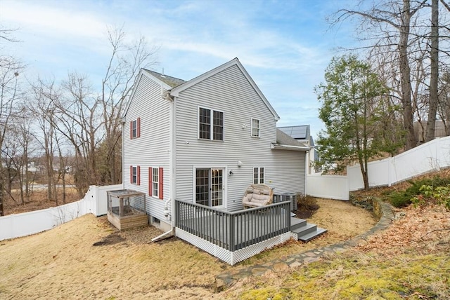 rear view of property with a deck, cooling unit, and a fenced backyard