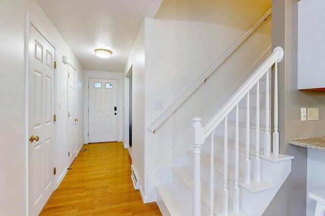 doorway featuring light wood-style floors, baseboards, visible vents, and stairway