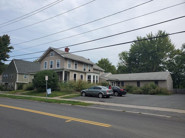 view of front of house featuring uncovered parking and a chimney