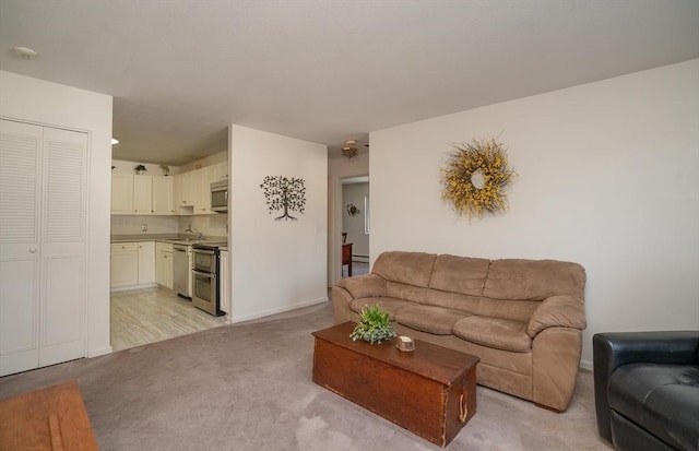 living room featuring sink and light carpet