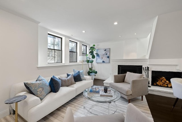 living room with a brick fireplace, wood finished floors, and baseboards