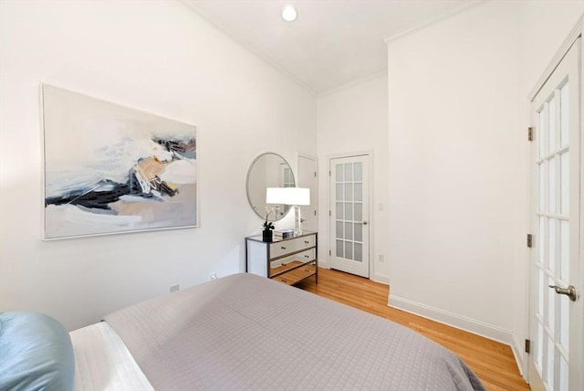 bedroom with baseboards, ornamental molding, recessed lighting, light wood-style flooring, and french doors