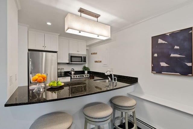 kitchen with a sink, stainless steel appliances, a peninsula, and white cabinetry