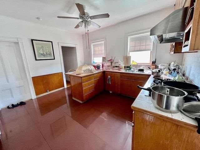 kitchen featuring kitchen peninsula, sink, dark tile patterned floors, and extractor fan