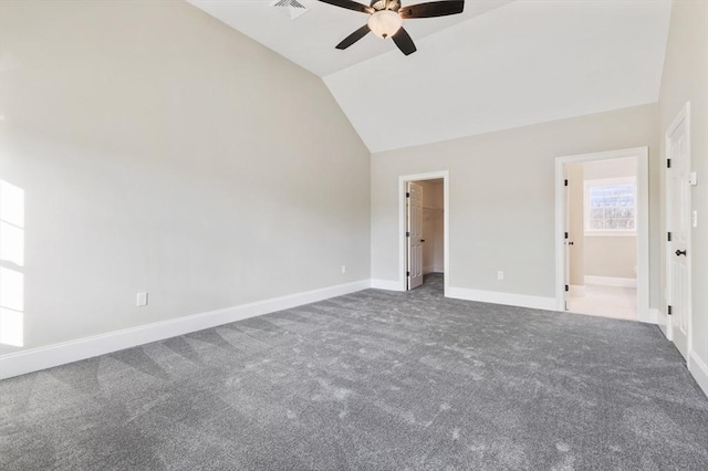 unfurnished bedroom featuring dark colored carpet, ceiling fan, a walk in closet, and vaulted ceiling