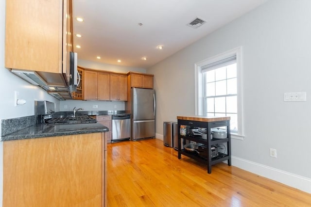 kitchen featuring stainless steel appliances, baseboards, light wood-style floors, and visible vents