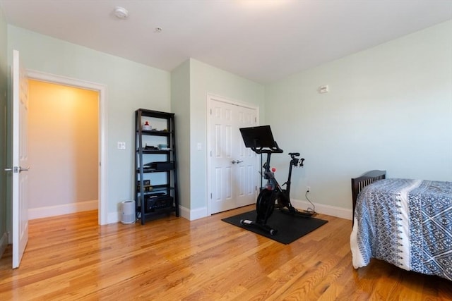 exercise area featuring light wood-style flooring and baseboards