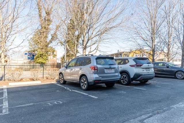 uncovered parking lot featuring fence