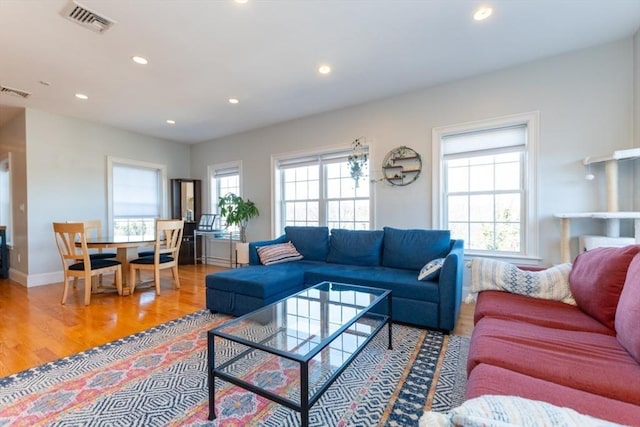 living room featuring wood finished floors, recessed lighting, a healthy amount of sunlight, and visible vents