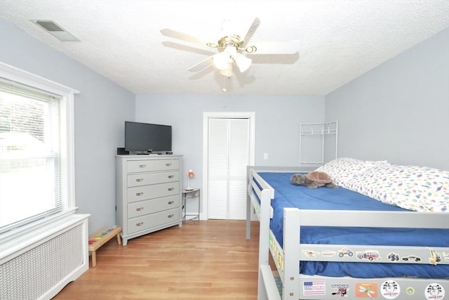 34 Pinecrest Rd, West Bridgewater, MA 02379 - bedroom featuring radiator, wood finished floors, a textured ceiling, a closet, and a ceiling fan