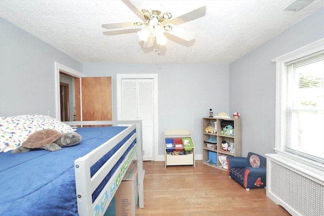 34 Pinecrest Rd, West Bridgewater, MA 02379 - bedroom with radiator heating unit, wood finished floors, a closet, a ceiling fan, and a textured ceiling