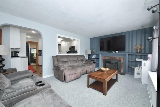 34 Pinecrest Rd, West Bridgewater, MA 02379 - living room with light carpet, arched walkways, a fireplace, and baseboards