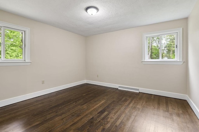 46 Blackmer, Sudbury, MA 01776 - spare room with plenty of natural light, dark wood-style flooring, baseboards, and a textured ceiling