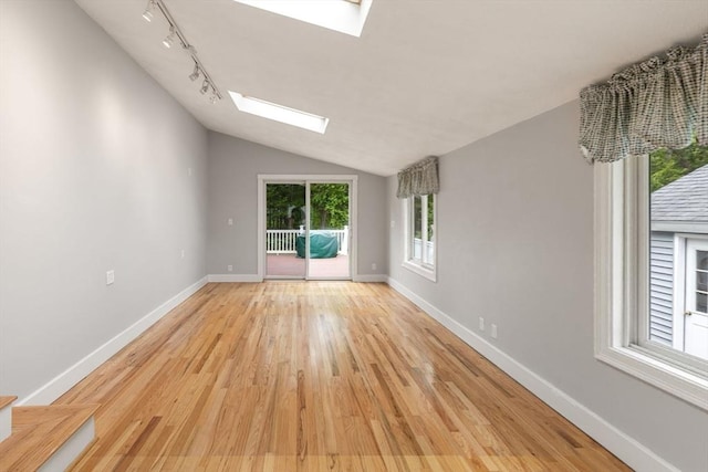 46 Blackmer, Sudbury, MA 01776 - unfurnished room with a skylight, light wood-style floors, vaulted ceiling, baseboards, and rail lighting