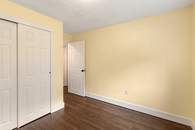 46 Blackmer, Sudbury, MA 01776 - unfurnished bedroom with dark wood-type flooring, baseboards, a closet, and a textured ceiling