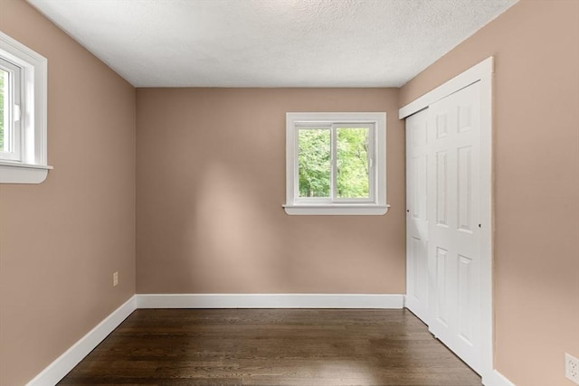 46 Blackmer, Sudbury, MA 01776 - unfurnished bedroom with dark wood finished floors, a closet, baseboards, and a textured ceiling
