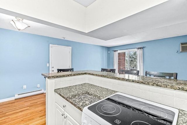 kitchen featuring baseboards, dark stone counters, electric range, light wood-style floors, and baseboard heating