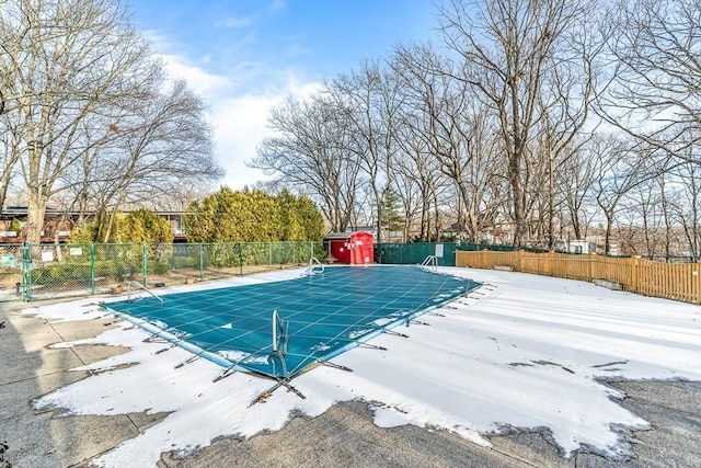 pool with a patio, fence, and an outdoor structure