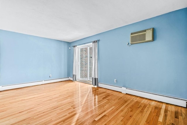 empty room with a baseboard heating unit, a wall unit AC, and wood finished floors