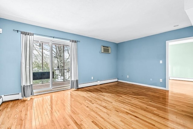 spare room with hardwood / wood-style floors, baseboards, a wall mounted air conditioner, a baseboard heating unit, and baseboard heating