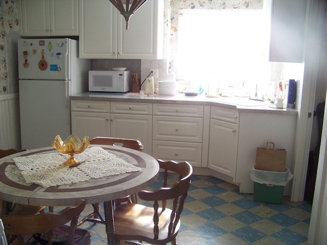 kitchen with white cabinetry and white appliances