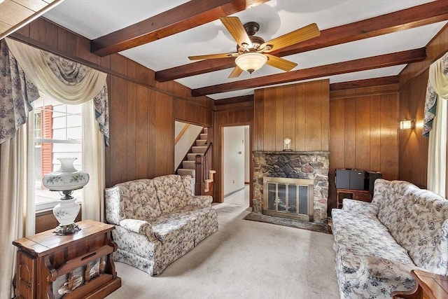 74 W Main St, Westminster, MA 01473 - living area with beam ceiling, wood walls, stairs, light colored carpet, and a stone fireplace