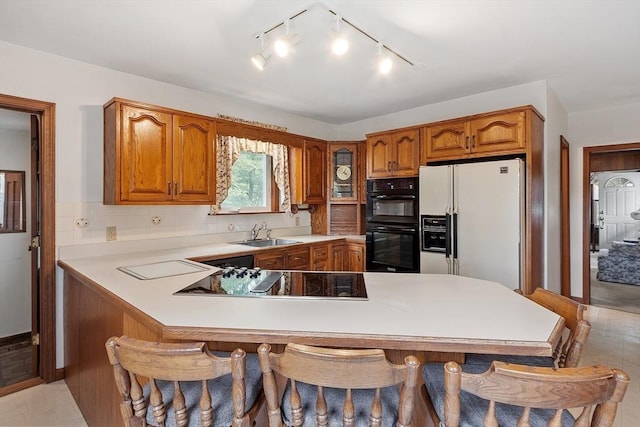 74 W Main St, Westminster, MA 01473 - kitchen featuring black appliances, a breakfast bar, brown cabinets, and light countertops
