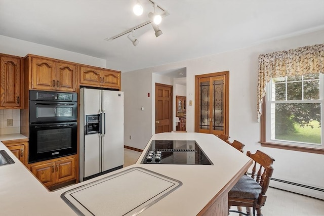 74 W Main St, Westminster, MA 01473 - kitchen with black appliances, light countertops, brown cabinets, a kitchen bar, and decorative backsplash