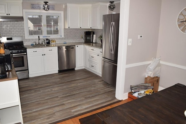 kitchen with sink, dark hardwood / wood-style floors, decorative backsplash, white cabinetry, and stainless steel appliances