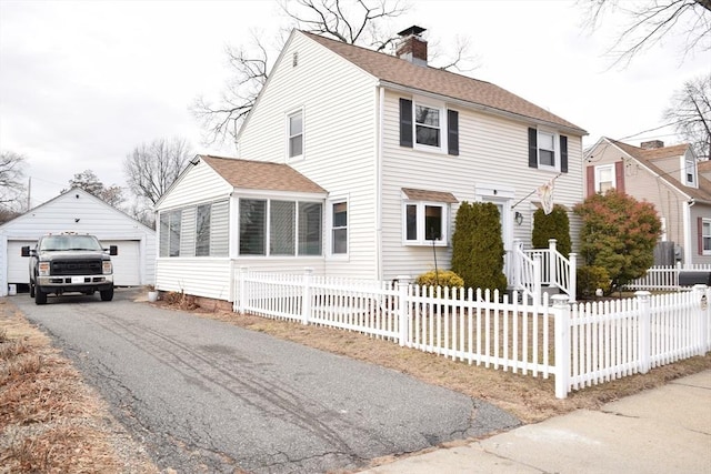 view of front of home with a garage and an outbuilding