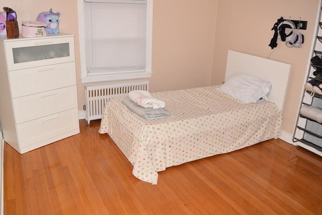 bedroom with hardwood / wood-style floors and radiator