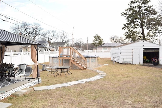 view of yard featuring a gazebo, a swimming pool side deck, and an outbuilding