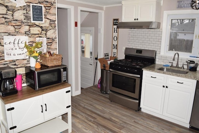 kitchen featuring white cabinets, appliances with stainless steel finishes, decorative backsplash, and sink