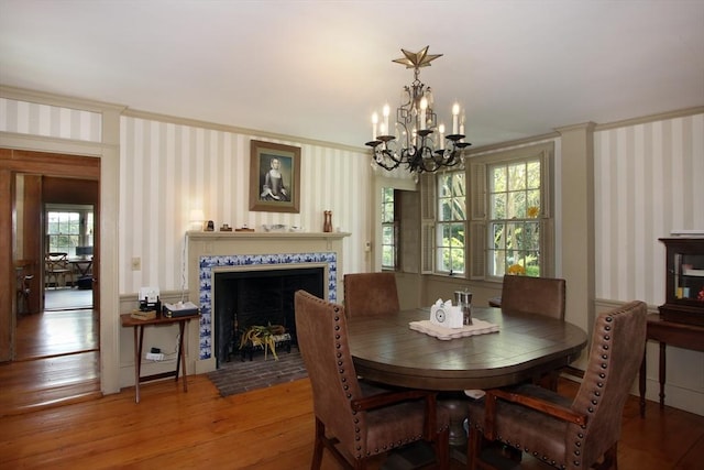 dining room featuring wood-type flooring, crown molding, and an inviting chandelier