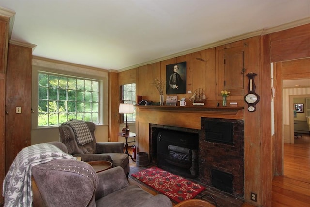 living room with hardwood / wood-style floors, wooden walls, and crown molding