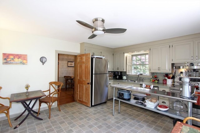 kitchen featuring tasteful backsplash, stainless steel refrigerator, ceiling fan, and sink