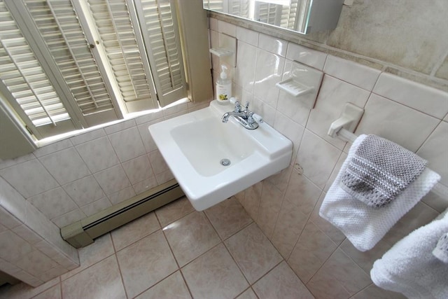 bathroom with tile patterned flooring, sink, tile walls, and a baseboard heating unit