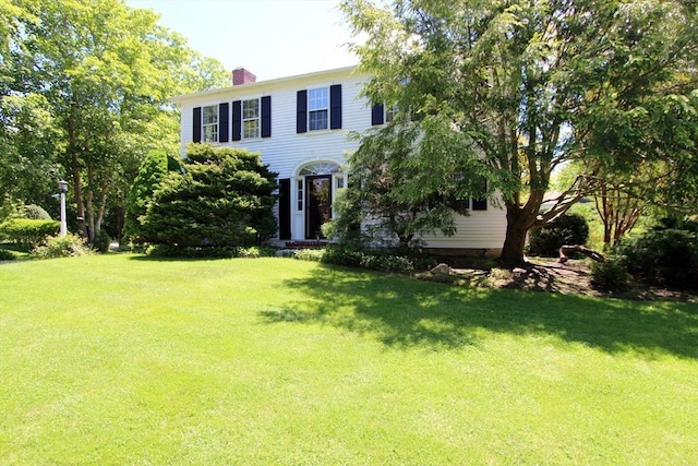 colonial house featuring a front lawn