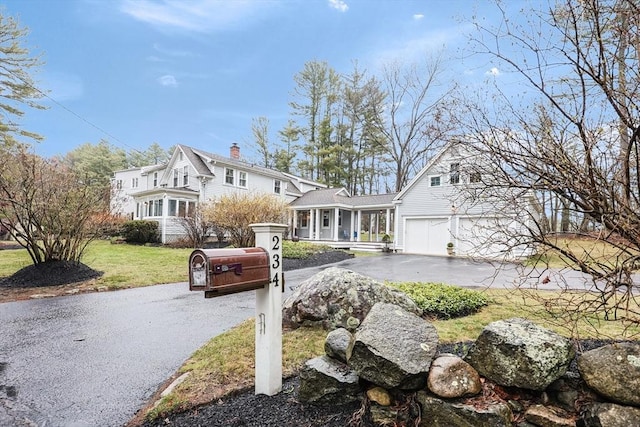 view of front facade with aphalt driveway and a front yard