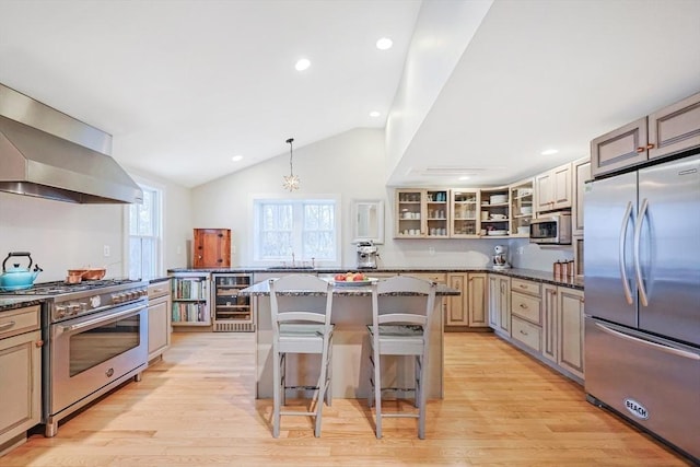 kitchen featuring wall chimney exhaust hood, glass insert cabinets, vaulted ceiling, stainless steel appliances, and wine cooler