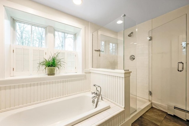 full bath with a shower stall, tile patterned floors, a bath, and a baseboard radiator
