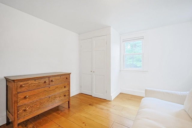 living area featuring light wood-type flooring and baseboards
