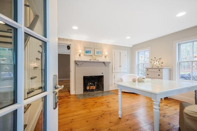 office featuring recessed lighting, light wood-style flooring, crown molding, and a brick fireplace