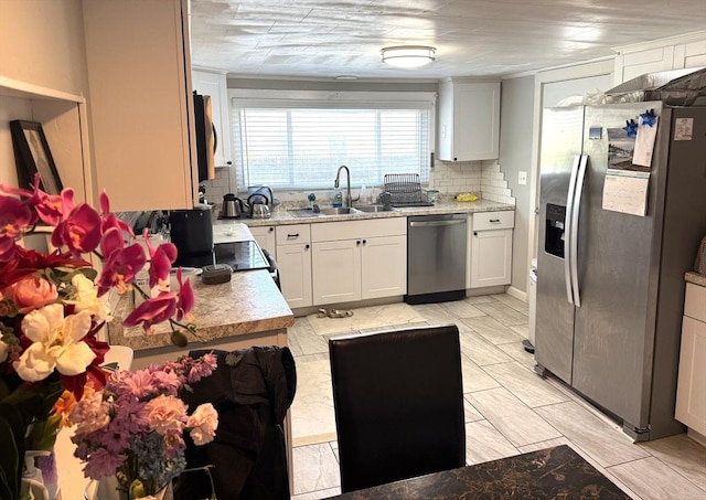 626 Nashua Rd, Dracut, MA 01826 - kitchen with decorative backsplash, appliances with stainless steel finishes, a sink, light countertops, and white cabinets