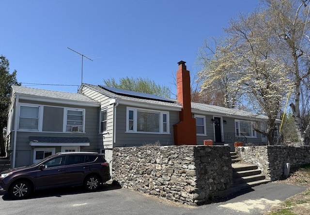626 Nashua Rd, Dracut, MA 01826 - single story home featuring solar panels, roof with shingles, and a chimney