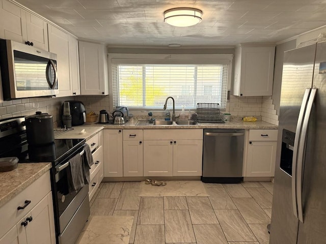 626 Nashua Rd, Dracut, MA 01826 - kitchen with decorative backsplash, a sink, ornamental molding, stainless steel appliances, and white cabinetry