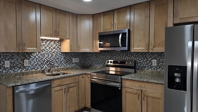 kitchen with backsplash, stone counters, stainless steel appliances, and a sink